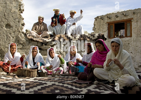Villagers spin wool and knit together in mountain village of Altit in Karokoram Mountains Pakistan Stock Photo