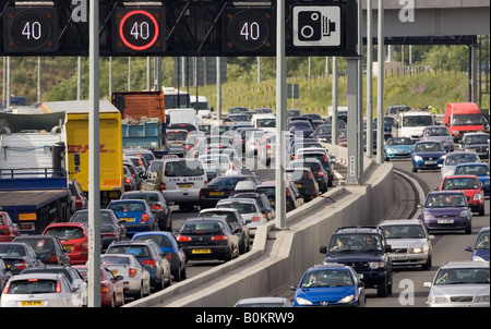 Man inspects vehicle damage after accident in traffic congestion on M25 motorway near London United Kingdom Stock Photo