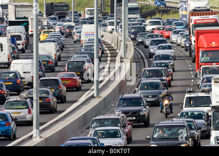 Cars and a motorcyclist in traffic congestion on M25 motorway near London United Kingdom Stock Photo