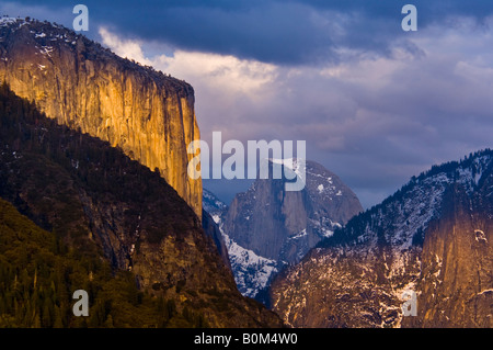 Sunset light on El Capitan and storm clouds over Half Dome and Yosemite Valley Yosemite National Park California Stock Photo