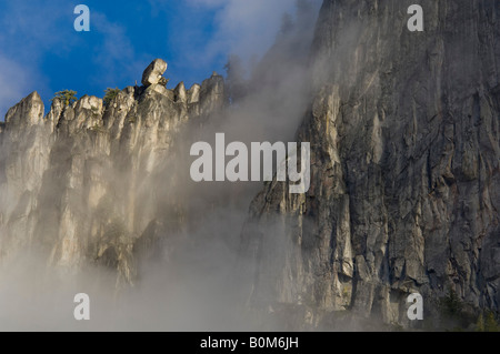 Clouds and sheer granite cliff walls above Yosemite Valley Yosemite National Park California Stock Photo