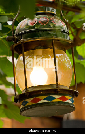 Painted Roses and Castles style Hurricane lamp converted into an electric light. UK Stock Photo