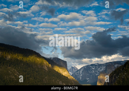 Cumulus clouds in spring over El Capitan and Half Dome Yosemite Valley Yosemite National Park California Stock Photo