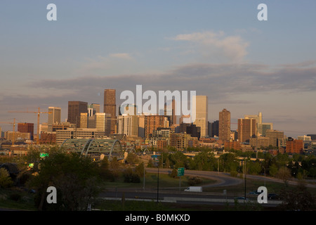 City skyline view from the west of Denver Colorado office buildings highways and skyscrapers at sunset dusk with purple clouds Stock Photo