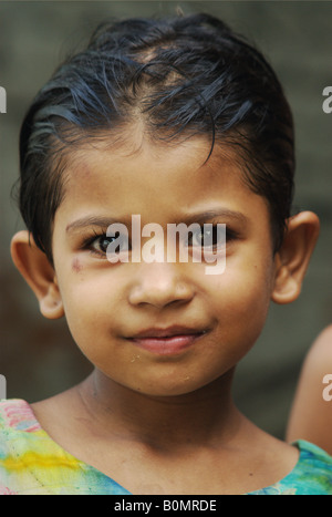 A young school girl with freshly washed hair poses for a photo in a small town near Kathmandu, Nepal Stock Photo