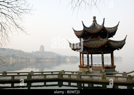 A pavillion and hillside pagoda reflecting in the waters of West Lake Hangzhou Zhejiang Province China Stock Photo