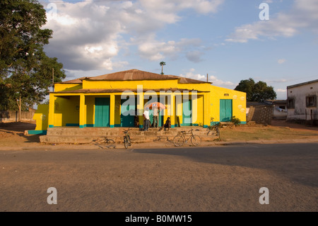 House with open air telephone shop painted in the colours of the Mozambiqan telelephone company Mcel. Mozambique. Stock Photo