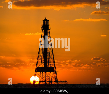 A brilliant fiery orange sky sunset over the ocean behind silhouette of Alligator Reef Lighthouse off Islamorada in the Florida Keys USA. Stock Photo