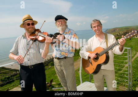 Three traditional acoustic folk musicians playing music at Druidston Haven Pembrokeshire Coast National Park WALES UK Stock Photo