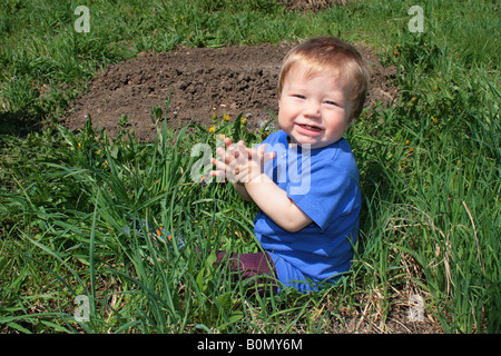 Child with the bouquet of dandelions in the hands Stock Photo