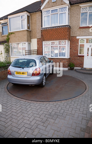 Rotating turntable platform to spin parked car for easy access to domestic driveway. Stock Photo