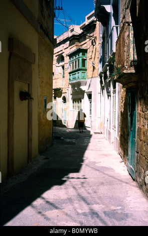 Small back street with traditional wooden balconies (Gallarijas) in the Maltese capital of Valletta. Stock Photo