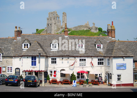 The Greyhound Inn with Castle ruins behind, The Square, Corfe Castle, Dorset, England, United Kingdom Stock Photo