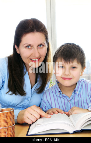 Teacher or tutor helping school boy to study Stock Photo