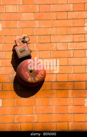 Old fire alarm on red brick wall Stock Photo