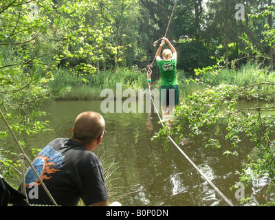 student crossing river by rope ladder Stock Photo