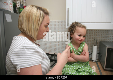 Mother telling her stubborn toddler daughter off, the terrible twos. Stock Photo
