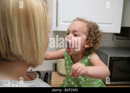 Toddler having a temper tantrum and screaming at her mother Stock Photo