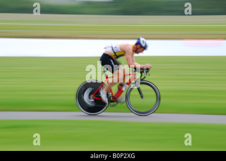 Racing cyclist on track alongside lake, Eton College Rowing Centre, Dorney Lake, Windsor, Berkshire, England, United Kingdom