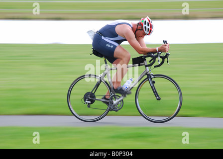 Racing cyclist on track alongside lake, Eton College Rowing Centre, Dorney Lake, Windsor, Berkshire, England, United Kingdom