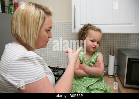 Mother telling her stubborn toddler daughter off, the terrible twos. Stock Photo