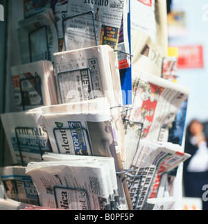 Newspaper stand selling international foreign newspapers for sale on a paper display rack outside newsagents shop in London, England UK  KATHY DEWITT Stock Photo