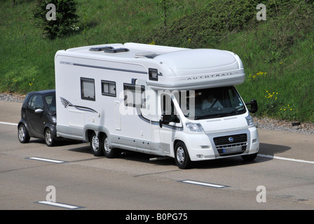 M25 motorway motorhome towing its own small car double rear axle obscured numberplate Stock Photo