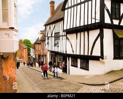 Tourists in Lincoln, UK walking up historic street of Steep Hill Stock Photo