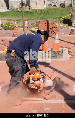 Workers cutting and laying red brick in pedestrian mall, Cape May, New Jersey, USA Stock Photo