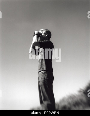 Black and white image of man looking through binoculars Stock Photo