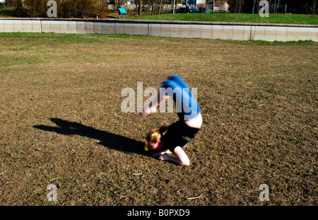 young woman doing gymnastics outdoors Stock Photo