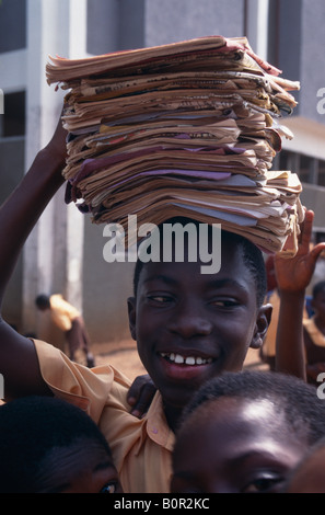 Carrying exercise books on his head a boy at Okuapemman School Akropong in Ghana Stock Photo