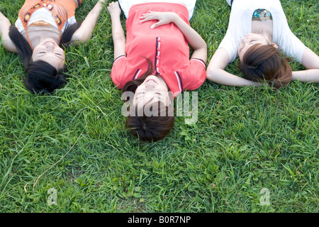 Three young women lying on grass Stock Photo