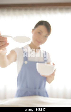 Portrait of female nurse feeding with spoon, defocused Stock Photo