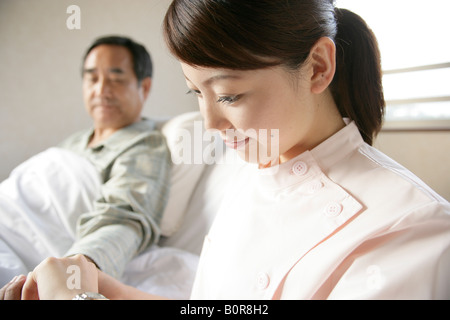 Nurse taking patient's blood pressure Stock Photo