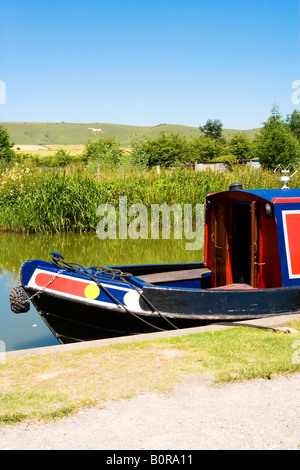 Narrowboat prow moored at Honeystreet, on the Kennet & Avon Canal, Wiltshire with the Alton Barnes White Horse in the distance. Stock Photo