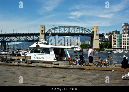 Vancouverites and tourists enjoying a sunny warm day on the big wharf at the False Creek waterfront on Granville Island Stock Photo