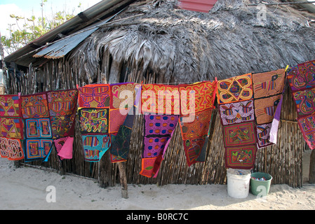 A line of molas for sale in front of a palapa on the kuna yula traditional island of isla tigre in the san blas islands, panama Stock Photo