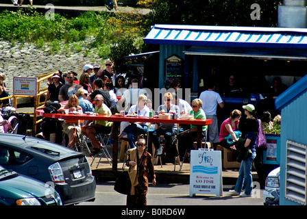 Patrons of a popular outdoor fish and chip shop that overlooks the entrance to Vancouver's False Creek waterfront. Stock Photo