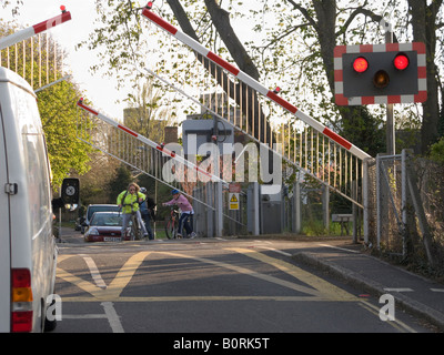 Railway level crossing barrier arms being raised to allow the traffic to flow. Stock Photo