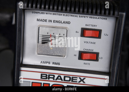 Car battery charger charges a flat 12v car battery in a BMW Z4 car Stock Photo