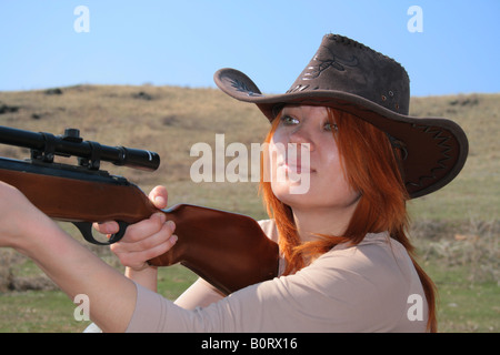 The young woman with rifle is shooting Stock Photo