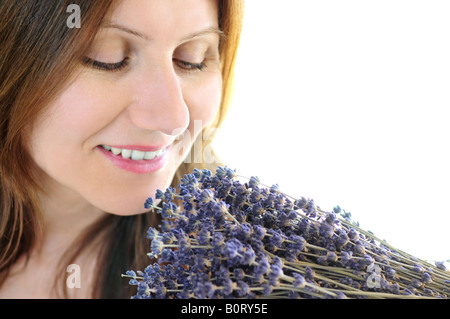 Mature woman smelling bunch of dried lavender Stock Photo