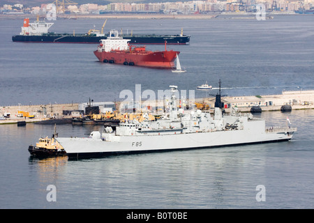 F85 HMS Cumberland being escorted in to Gibraltar s inner harbour Stock Photo