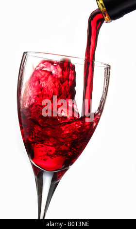 Red wine being poured into a glass against a white background Stock Photo