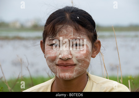 Young Burmese woman wearing typical Thanaka cosmetic mask in a rural area, Myanmar, Burma Stock Photo