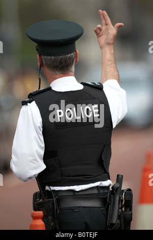 PSNI police service northern ireland officer sergeant giving traffic hand signals on patrol in belfast Stock Photo