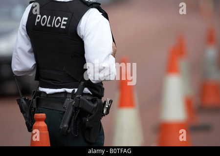 PSNI police service northern ireland officer sergeant standing watching traffic in coned off roadside area ni Stock Photo