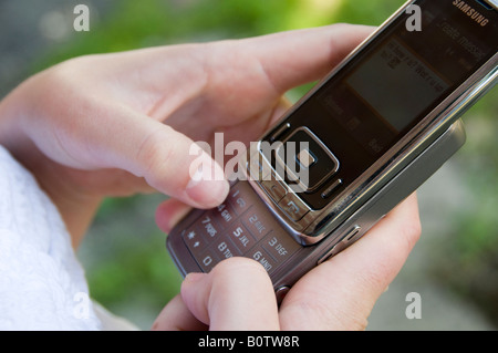 Close-up of woman hands text messaging with her mobile at coffee shop ...