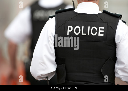 male PSNI police service northern ireland sergeant on patrol with colleague wearing stab proof vests Stock Photo